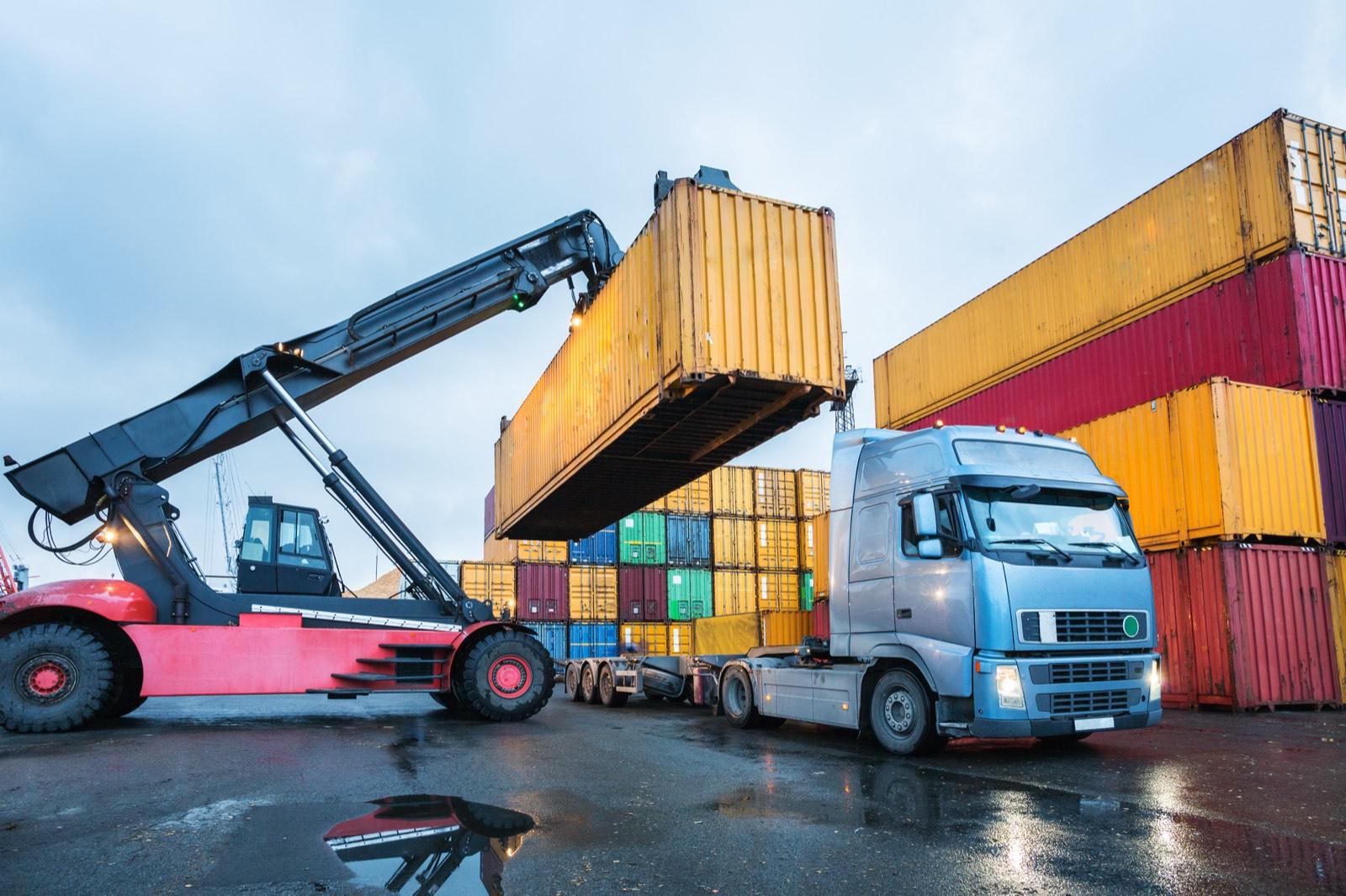 Stortruck med containeråk på terminal